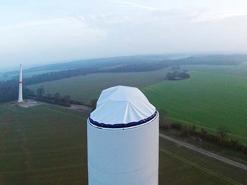 Concrete tower covering, hybrid tower covering, woven tarpaulins for the wind energy sector